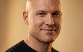 Confident man with clean shaved head showing natural-looking results from men's scalp micropigmentation