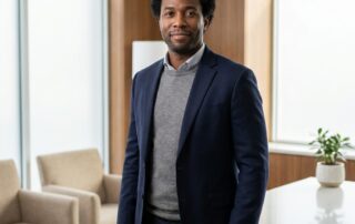 Confident man with a natural full hairline in a modern consultation setting, representing hair transplant options for men